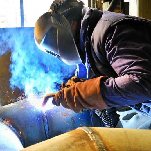 A person welding while wearing a welding helmet.