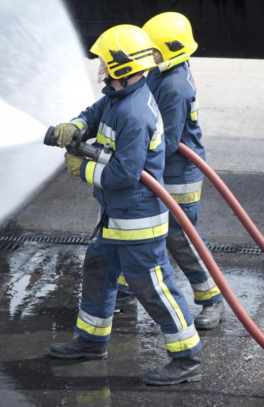 Firefighters extinguish fire with water hoses.