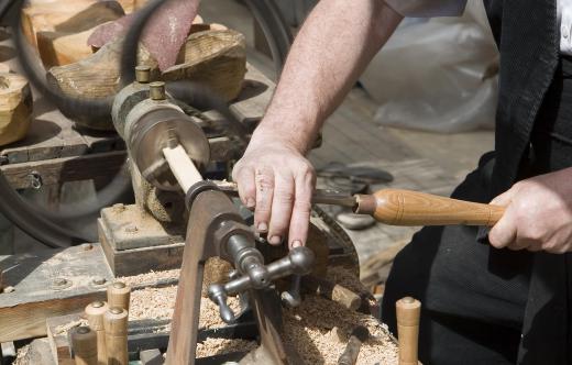 A wood turning chisel is used to cut wood that’s being rapidly turned on a lathe.