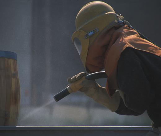 Sandblasting while wearing protective clothing.