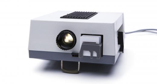 In a slide projector, the light source is located in close proximity to the photo slide.