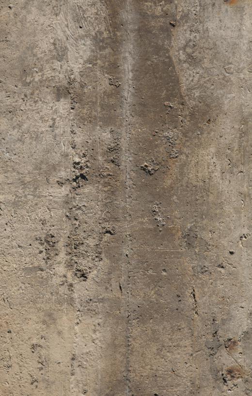 Spalling concrete shows pits and cracks.